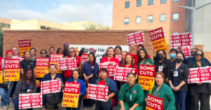 Group of CommonSpirit nurses with signs "Some Cuts Don