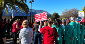 Watsonville nurse, staff, community, holding sign "Some cuts don